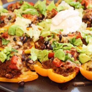 Bell pepper nachos topped with ground beef, beans, salsa, avocado, and sour cream.