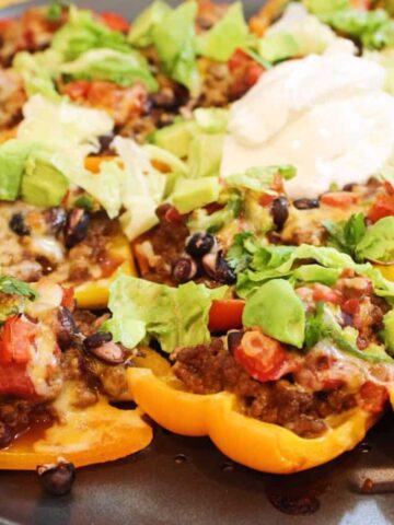 Bell pepper nachos topped with ground beef, beans, salsa, avocado, and sour cream.