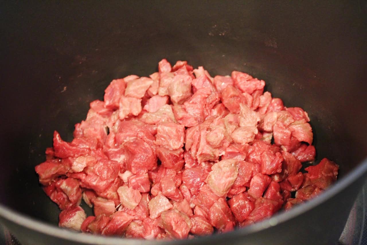 Beef stew meat in a large pot.