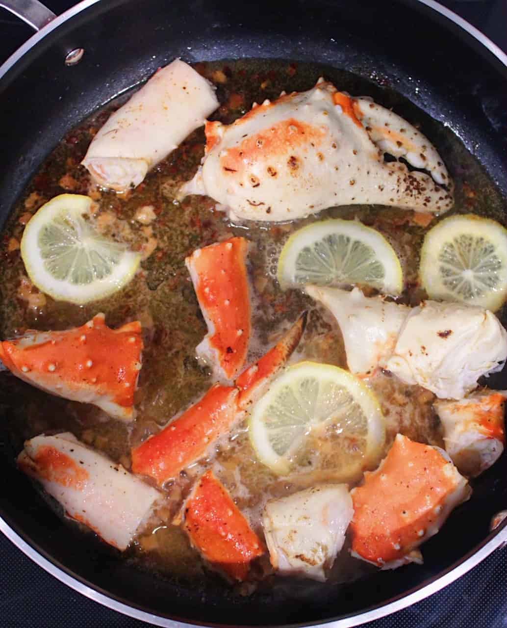 Crab claws and legs simmering in white wine sauce.