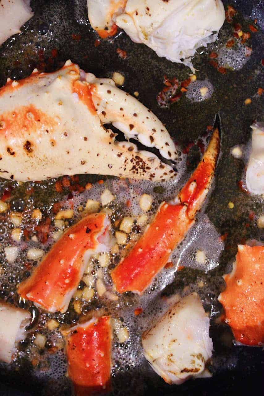 Crab claws and legs cooking in butter with garlic.