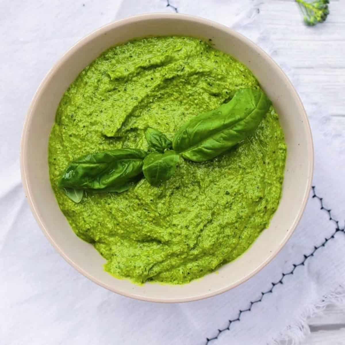 Broccoli pesto in a tan bowl.