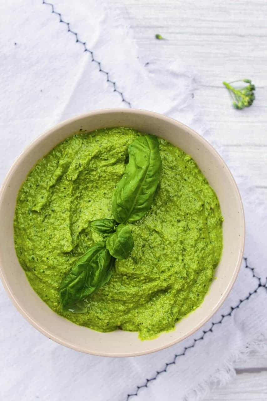 Basil broccoli sauce in a bowl on a white dish towel.