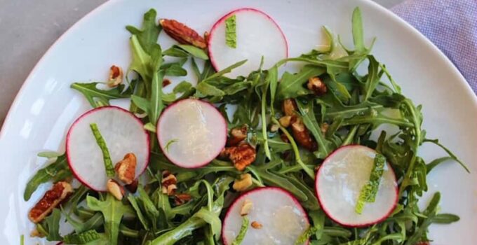 Radish salad with honey mustard vinaigrette on a white plate.