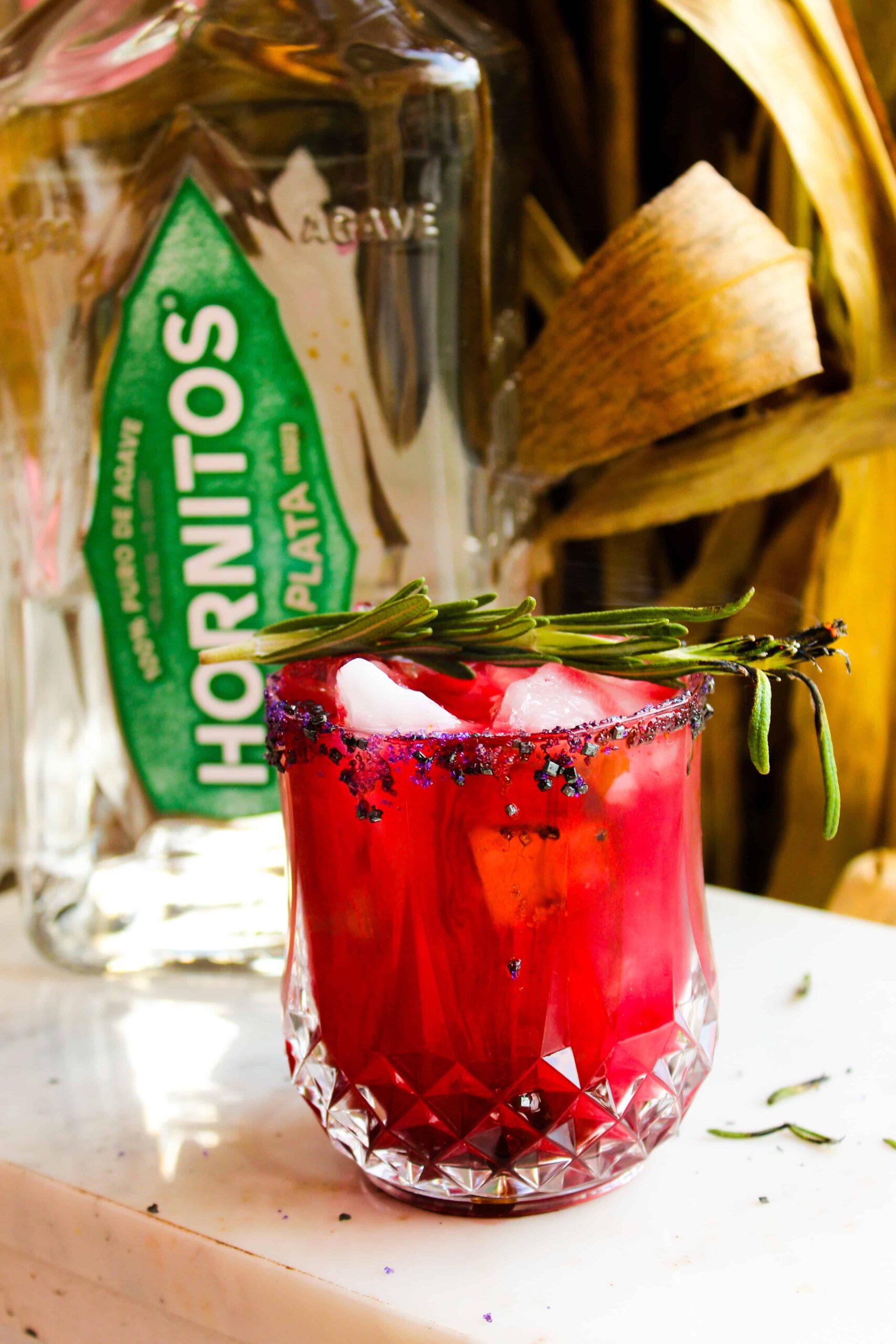 Halloween tequila cocktail with smoking rosemary sprig garnish.