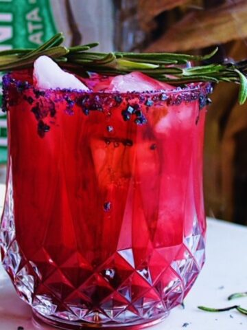 Bright red, pink Halloween margarita in rocks glass with sugar rim.