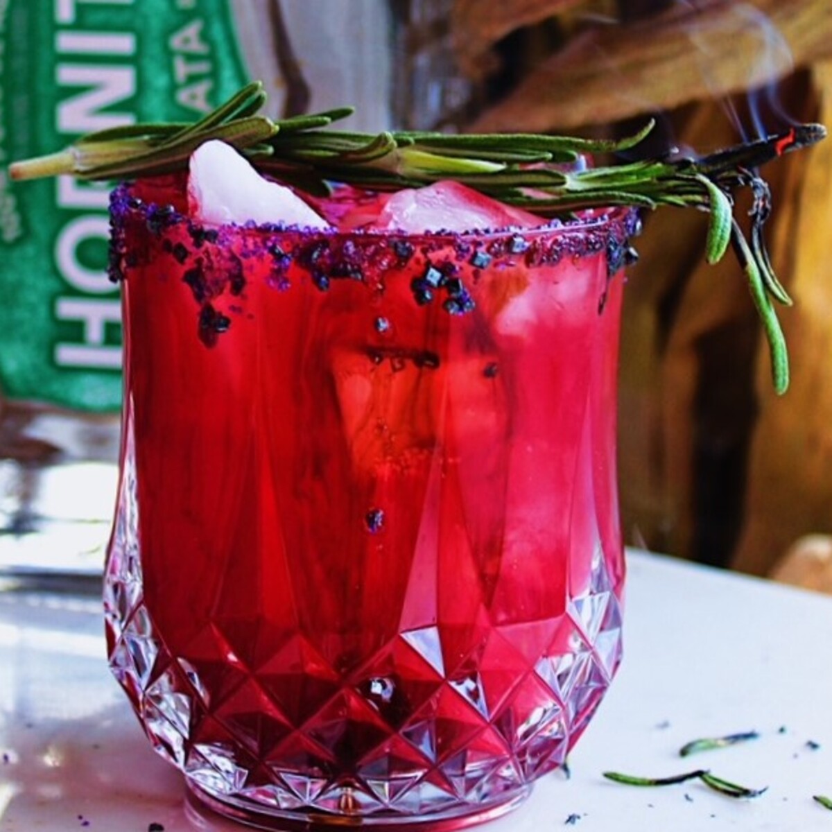 Bright red, pink Halloween margarita in rocks glass with sugar rim.