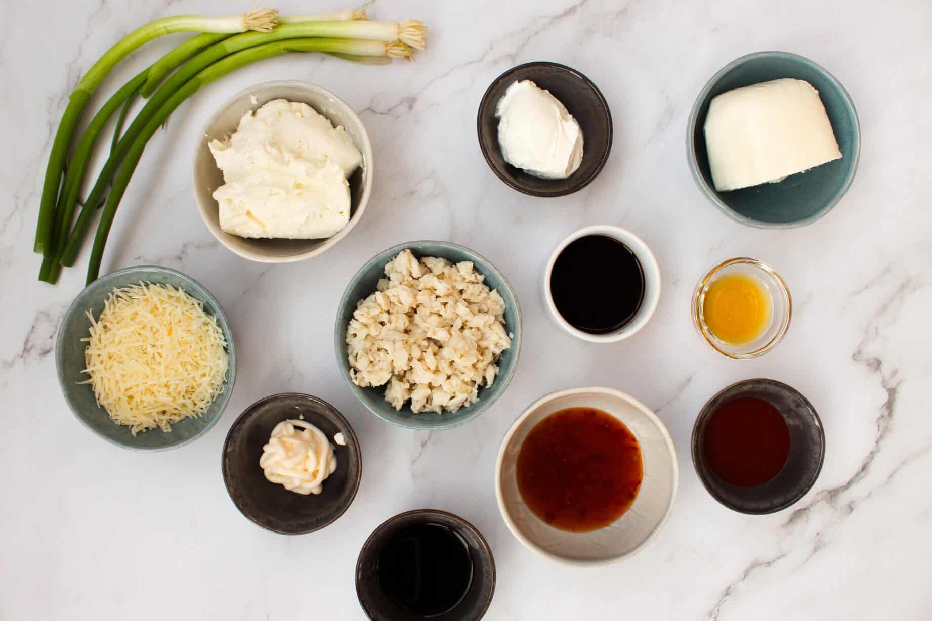 Crab Rangoon Dip ingredients in bowls on a marble counter.