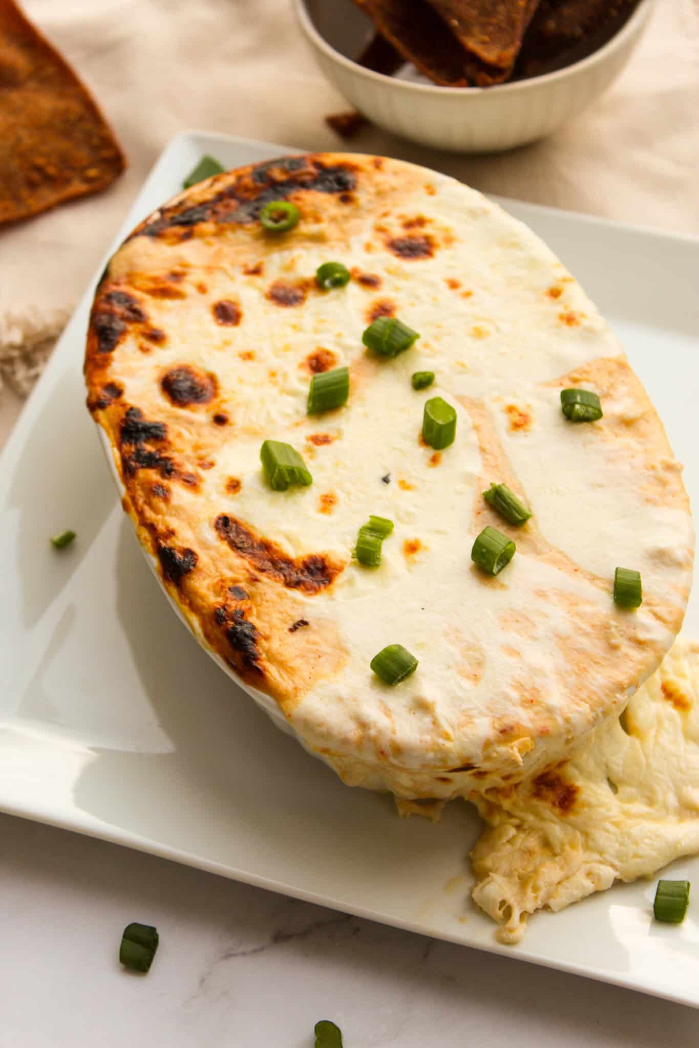 Cheesy dip overflowing from baking dish.